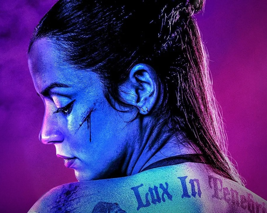 Image of Ana de Armas in Ballerina with dramatic lighting in neon blue and purple tones.