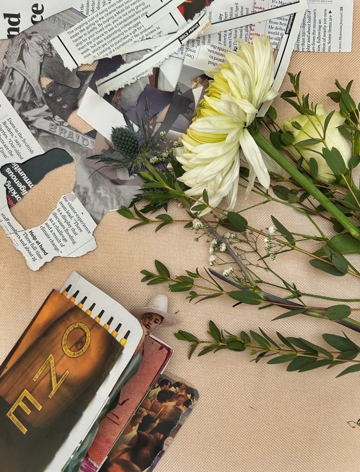 color photograph of a collage of a yellow flower and cut greens with newspaper clippings and books